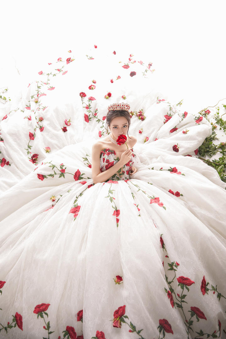 手拿玫瑰的美女明星迪丽热巴婚纱照图片欣赏