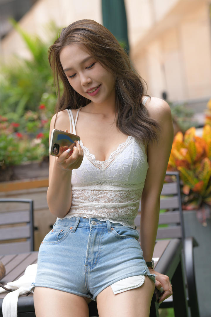 玩手机的长腿热裤美女图片